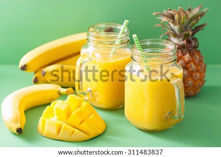 healthy yellow smoothie with mango pineapple banana in mason jars
