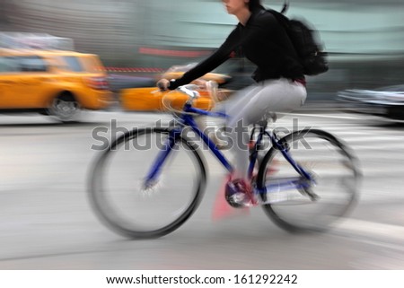 cyclist in traffic on the city roadway  motion blur