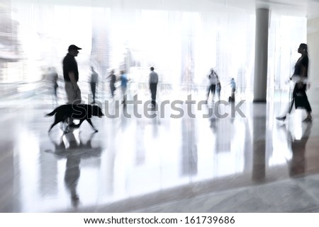 abstakt image of people and security guard with a dog in the lobby of a modern business center with a blurred background