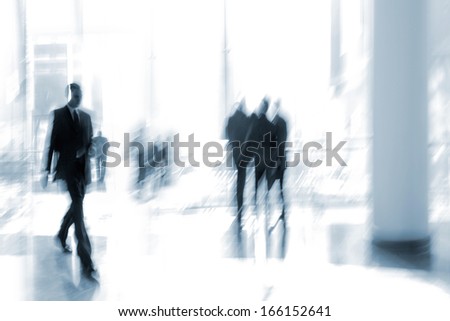 abstakt image of people in the lobby of a modern business center with a blurred background and  blue tonality