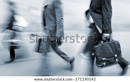 Business people at rush hour walking in the street, in the style of motion blur and blue tonality