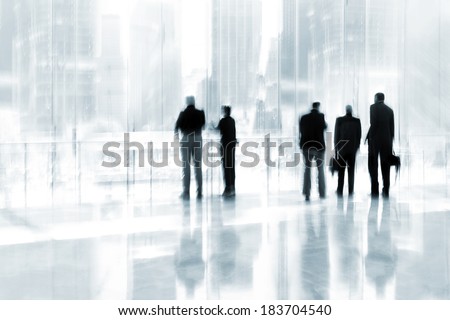abstrakt image of people in the lobby of a modern business center with a blurred background and blue tonality
