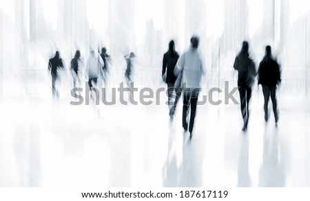 abstract image of people in the lobby of a modern business center with a blurred background and blue tonality