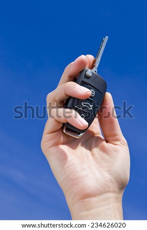 car key in hand on blue sky background