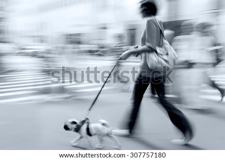 walking the dog on the street in motion blur and blue tonality