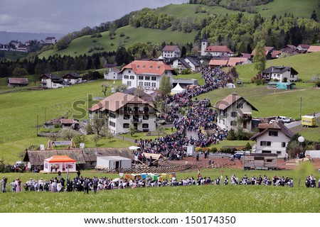 ALPS, SWITZERLAND - CIRCA JUNE, 2013 The ascent to the mountain pastures with the herds around late spring is a traditional festival in Swiss Alpine villages.