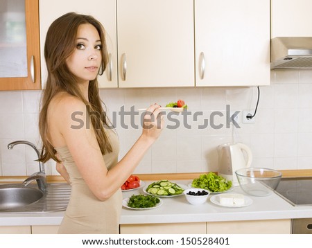 girl eating a greek salad in the kitchen, girl with a salad