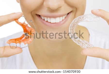 Beautiful Smiling Girl Holding Retainer For Teeth (Dental Braces) And Individual Tooth Tray