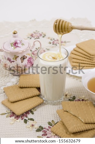 glass of buttermilk (milk) and cookies with honey