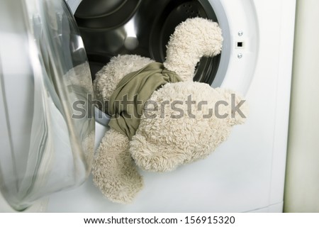 delicate washing soft toys: soft toy falling out of a washing machine (fluffy toy in the washing machine)