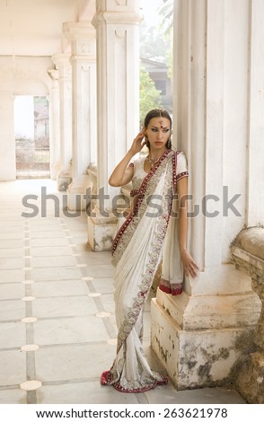 Beautiful young indian woman in traditional clothing with incense bridal makeup and oriental jewelry. Beautiful bollywood dancer in Sari posing in the eastern palace. Beautiful princess Girl praying