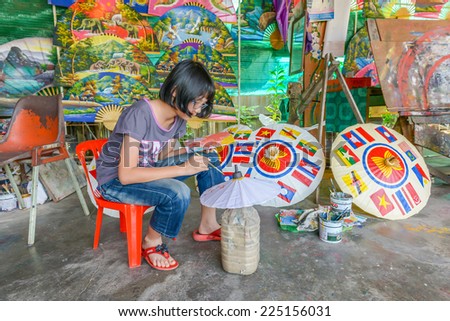 CHIANGMAI, THAILAND - October 20: An unidentified girl make paper umbrella in the village Bo Sang, Chiang Mai, Thailand. Bo Sang is known for its handmade umbrellas and parasols. October 20, 2014.