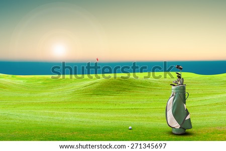 golf equipment and golf ball on green and hole as background.