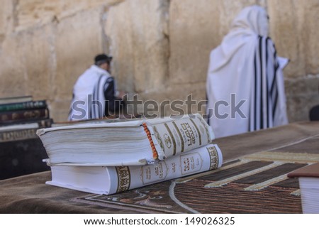 JERUSALEM - JULY 31 - Orthodox Jews prays at the Western Wall, behind praying book (Siddur) - July 31, 2013 in the old city of Jerusalem, Israel. This is the holiest place in Jewish tradition