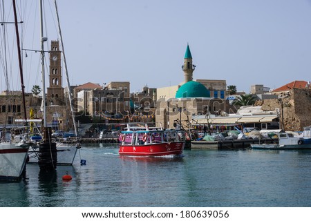 ACRE, ISRAEL - MARCH 06, 2014: Fishing boats, yachts and nearby monuments, in the fishing harbor in the old city of Acre, Israel. Acre is one of the oldest continuously inhabited sites in the world.