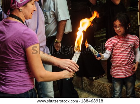 JERUSALEM - APRIL 19, 2014: The holy fire from the holy fire ceremony the Church of the Holy Sepulcher shared between pilgrims along the Via Dolorosa Street, on Holy Saturday, in Jerusalem, Israel