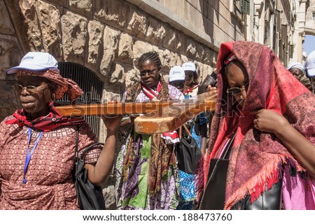 JERUSALEM - APRIL 18, 2014: Pilgrims from all over the world commemorating the crucifixion of Jesus Christ by carrying a cross along via dolorosa, on good Friday, in the old city of Jerusalem, Israel