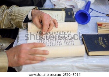 JERUSALEM, ISRAEL - MAR 05, 2015: An ultra-orthodox Jew reads the book of Esther (the megillah), as part of the traditions of the holiday of Purim, in Jerusalem, Israel
