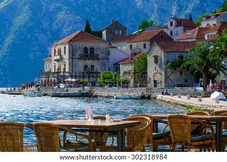 PERAST, MONTENEGRO - JUNE 28, 2015: Scene of the promenade, with cafes, old buildings, boats, locals and tourists, in Perast, Montenegro