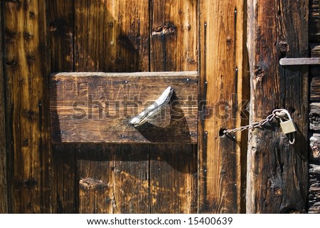 Old wooden door background. Detail of old mountain house closed  with padlock, Pusteria valley,Italy