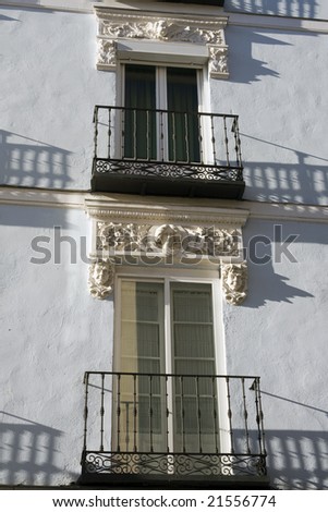 Shadow of wrought iron balcony railing.  Detail of old house facade, Segovia, Spain