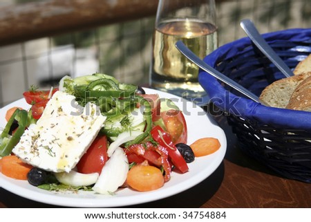 Greek salad or Horiatiki salad. Typical taverna meal, salad, bread and white wine. Crete - Greece