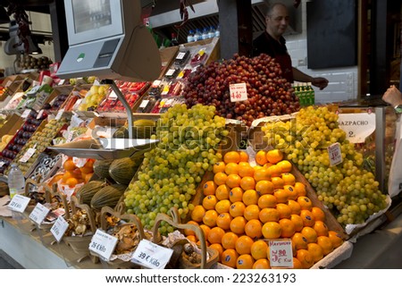 MADRID - OCTOBER 02: Mercado de San Miguel. Seller serves customer at the fresh fruits stand on October 02, 2014 in Madrid. Visitors can be  found fresh produce and specialty food and tapas