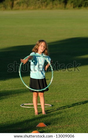 girl playing with hula hoop at park