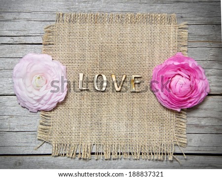Ranunculus flowers and letters LOVE on wood