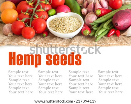 Raw organic hemp seeds in a bowl and vegetables