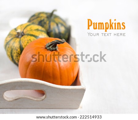 Pumpkins in a shabby chic tray on a white shabby table