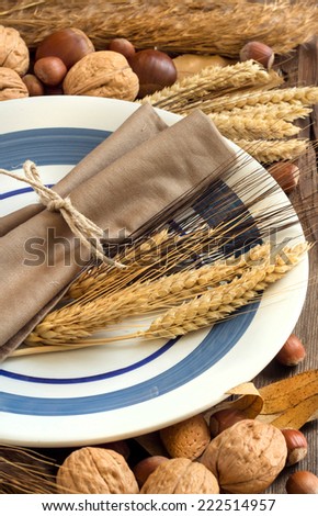 Autumn rustic table setting with nuts and wheat