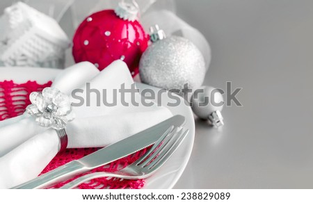 Red and silver Christmas ornaments border on silver background