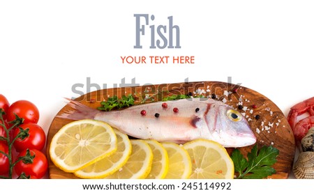 Fresh fish with seafood and vegetables on a wooden board isolated on white