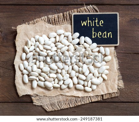 White beans with a small chalkboard on wood
