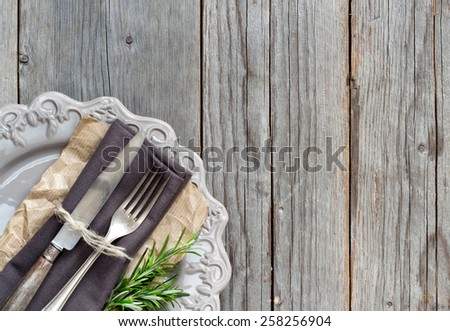 Vintage Table setting with napkin and plate on old wooden table