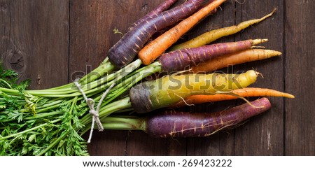 Fresh organic rainbow carrots on a wooden table