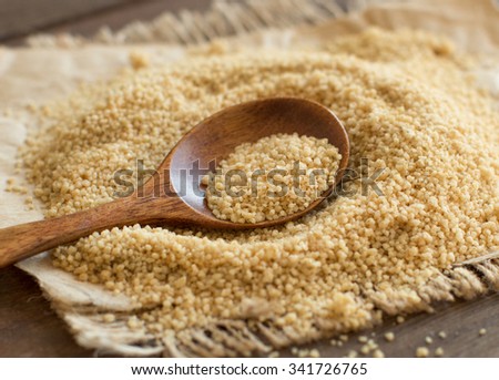 Pile of whole wheat CousCous with a spoon close up