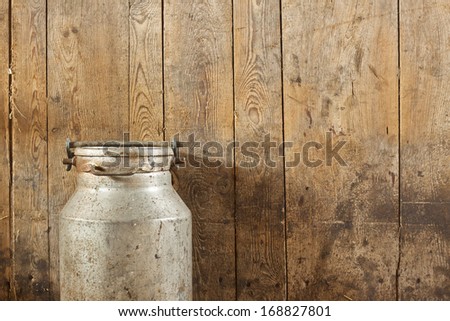 Milk can on wood vintage background