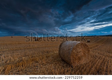 bale of hay and storm landscape