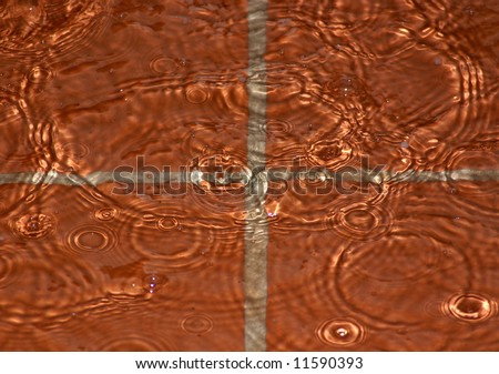 Ripples, circles and patterns in the water on flooded patio tiles
