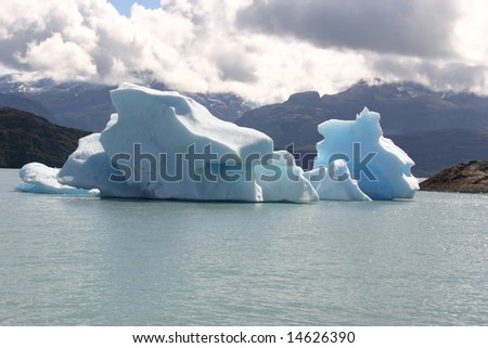 Iceberg in lake in Los Glaciares National Park, Calafate, Patagonia, Argentina with mountainous and cloudy background