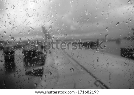 View out of a rain covered plane window in black and white