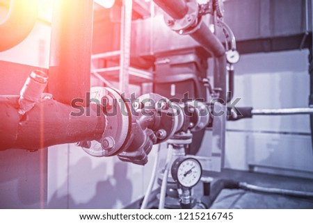 House heating system with many steel pipes, manometers and metal tubes, selective focus with light effect, blue toned