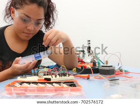 Female tech student learning how to wire a prototype circuit board