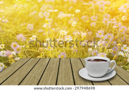 White coffee cup on vintage wooden with flowers soft focus background in the early morning