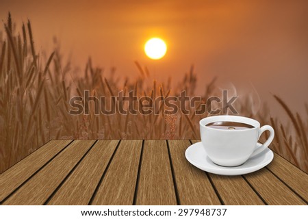 White coffee cup on vintage wooden and meadow and shiny sunlight background.