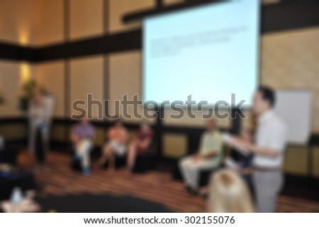 blurred conference room with projection screen