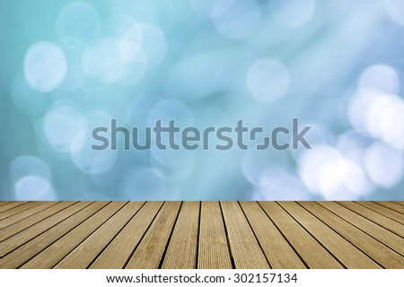 Shiny sunlight bokeh background with empty wooden deck table ready for product display montage. vintage color concepts