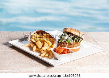 Salmon burger with fries and sauce